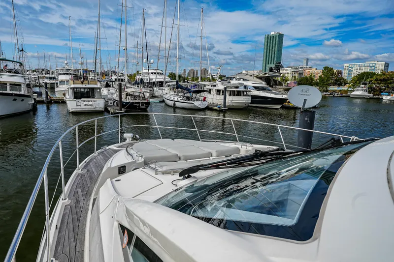 Slide: The Image of 2018 Sea Ray L590 Fly yacht docked in a marina with other boats. - 46