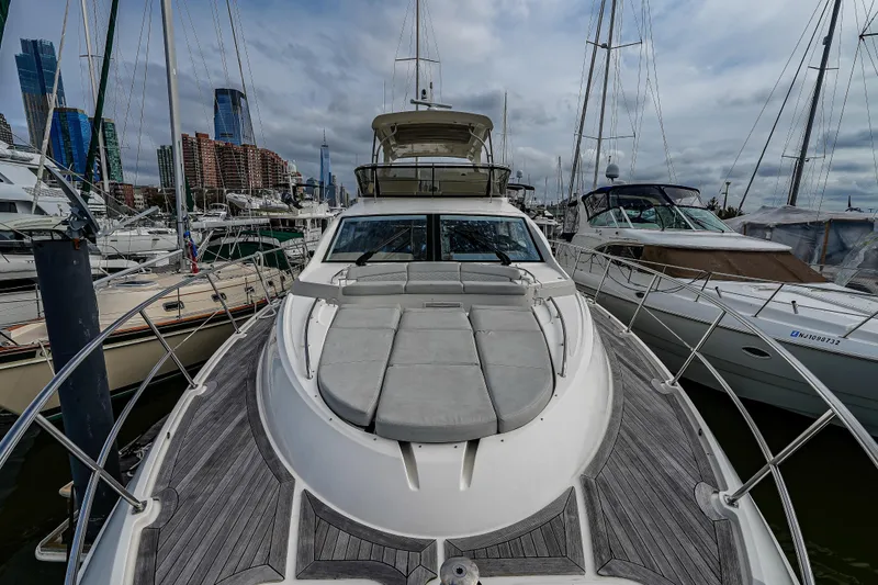 Slide: The Image of 2018 Sea Ray L590 Fly yacht docked in a marina with city skyline backdrop. - 47
