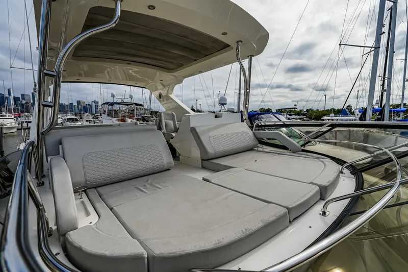 Slide: The Image of 2018 Sea Ray L590 Fly yacht with spacious sunbathing area in marina setting. - 49