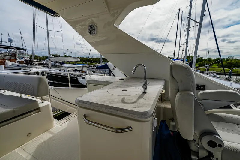 Slide: The Image of 2018 Sea Ray L590 Fly yacht interior with sink and seating at marina. - 52