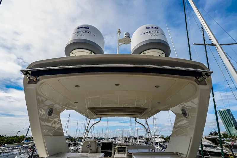 Slide: The Image of 2018 Sea Ray L590 Fly yacht with TracVision domes, docked at marina under blue sky. - 58