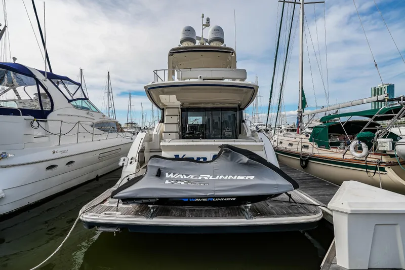 Slide: The Image of 2018 Sea Ray L590 Fly yacht docked with covered WaveRunner on platform. - 59