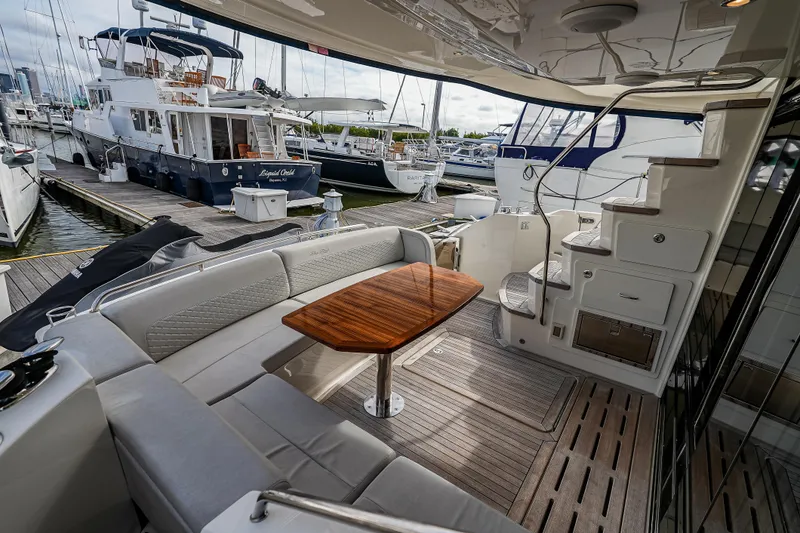 Slide: The Image of 2018 Sea Ray L590 Fly yacht interior with elegant seating and wooden table. - 6