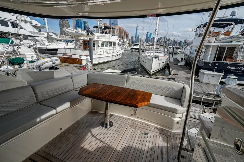 Slide: The Image of Luxurious 2018 Sea Ray L590 Fly yacht interior with elegant seating and wooden table in marina. - 8