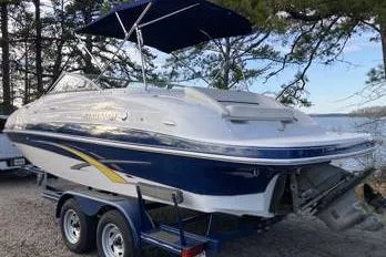 Slide: The Image of 2007 Four Winns 204 Funship boat on trailer, parked near a lake with trees. - 7