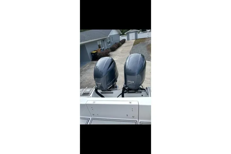 Slide: The Image of 2017 Sportsman Open 252 Center Console with dual outboard engines in driveway. - 3