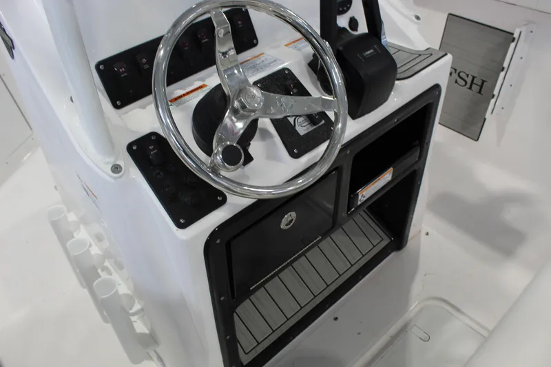 Slide: The Image of 2025 Yamaha Boats 222 FSH Sport steering console with controls and storage compartments. - 4