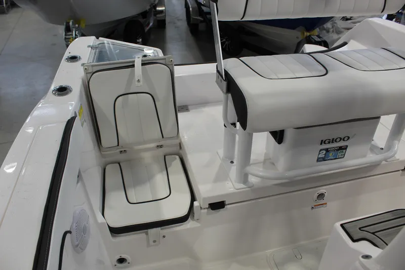 Slide: The Image of 2025 Yamaha Boats 222 FSH Sport interior seating with Igloo cooler and storage. - 6