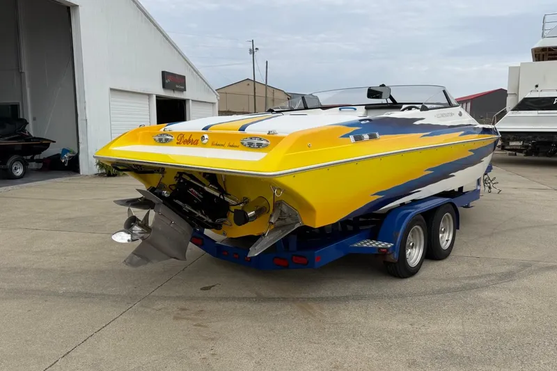 Slide: The Image of 2004 Eliminator 280 Eagle XP boat with vibrant yellow and blue design on trailer. - 3