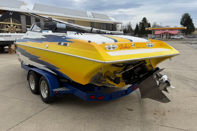 Slide: The Image of 2004 Eliminator 280 Eagle XP boat on trailer, vibrant yellow and blue design. - 4