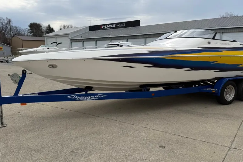 Slide: The Image of 2004 Eliminator 280 Eagle XP boat on blue trailer, parked outdoors. - 6