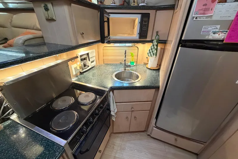 Slide: The Image of Compact kitchen in 2000 Carver 356 Aft Cabin Motor Yacht with stove, sink, and fridge. - 23