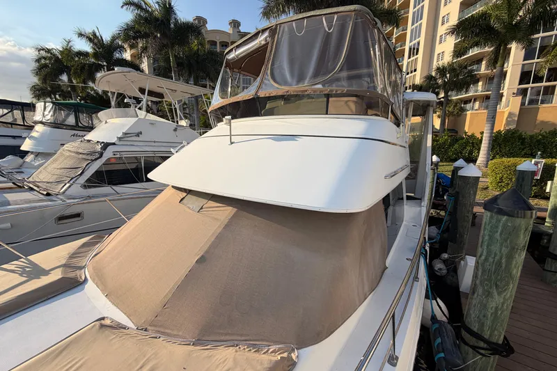 Slide: The Image of 2000 Carver 356 Aft Cabin Motor Yacht docked at marina with palm trees. - 5