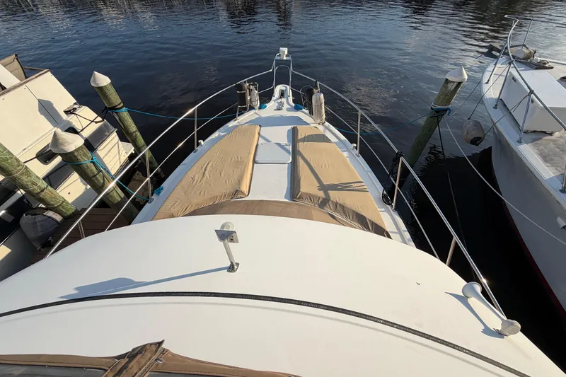 Slide: The Image of 2000 Carver 356 Aft Cabin Motor Yacht docked, featuring spacious deck and sunbathing area. - 4