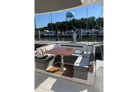 Slide: The Image of 2021 Tiara Sport 38 LS yacht with elegant seating and table, docked at a marina. - 3