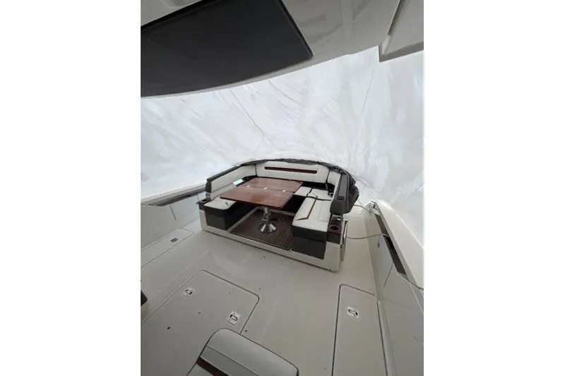 Slide: The Image of 2021 Tiara Sport 38 LS boat interior with seating and wooden table. - 8