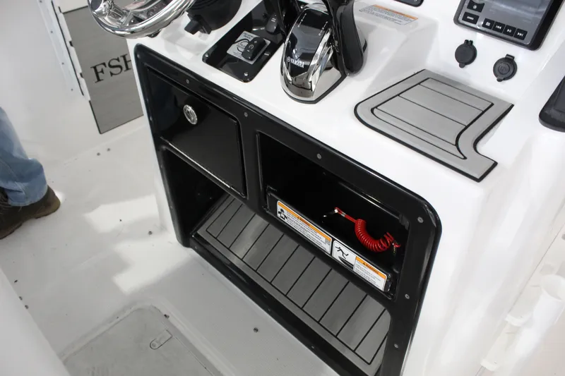 Slide: The Image of 2025 Yamaha Boats 222 FSH Sport E console with storage compartments and control panel. - 6