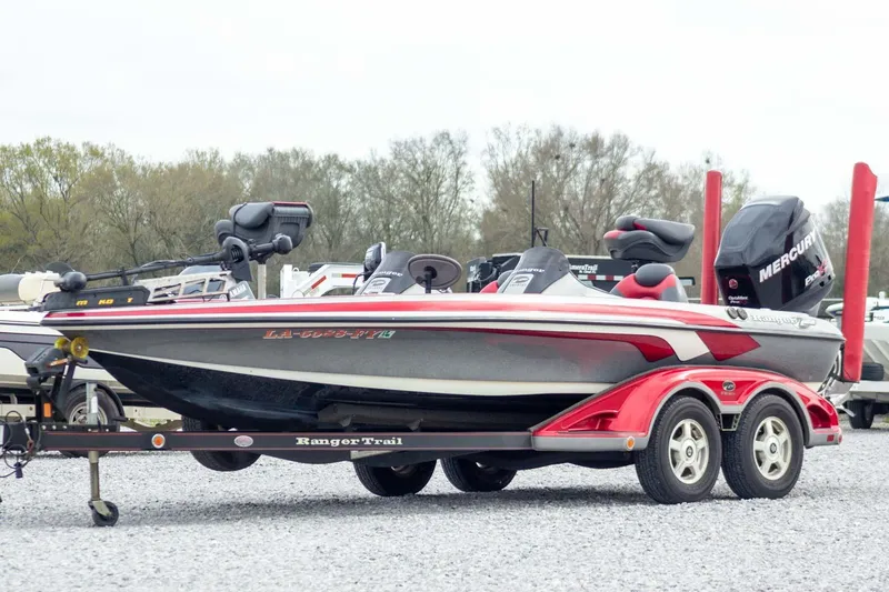 Slide: The Image of 2009 Ranger Z520 Comanche boat on trailer, featuring red and black design with Mercury engine. - 1
