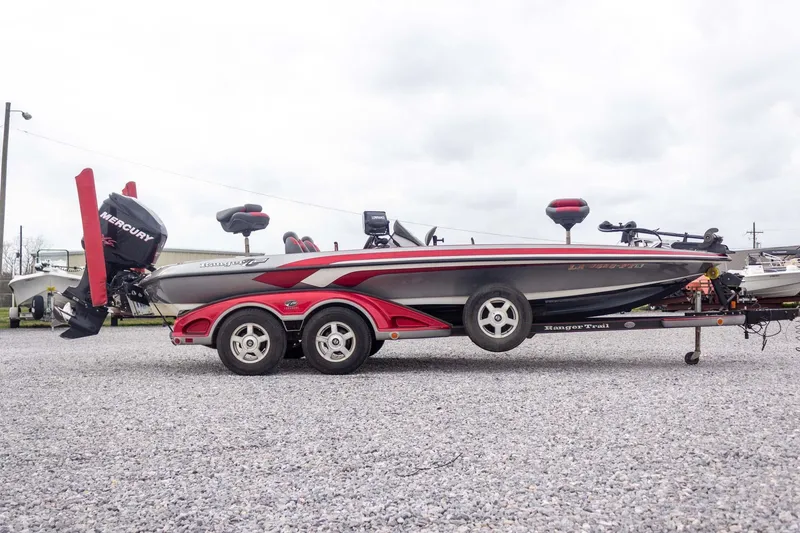 Slide: The Image of 2009 Ranger Z520 Comanche boat with Mercury engine on a trailer, parked on gravel. - 8