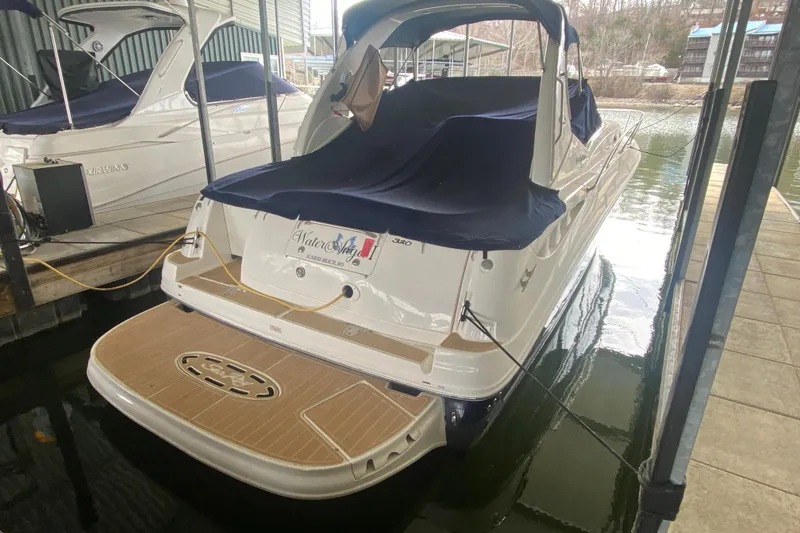 Slide: The Image of 2004 Sea Ray Sundancer 320 docked, covered with navy blue canvas, in a marina setting. - 10