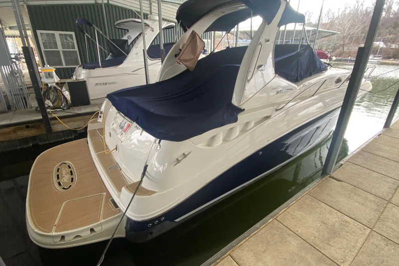 Slide: The Image of 2004 Sea Ray Sundancer 320 docked, covered with navy blue canvas, in a marina setting. - 11