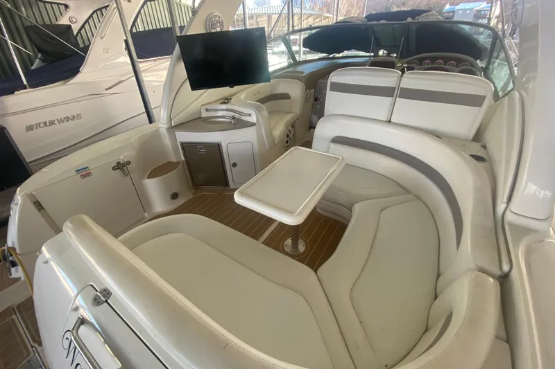 Slide: The Image of 2004 Sea Ray Sundancer 320 interior with seating, table, and mounted TV. - 16