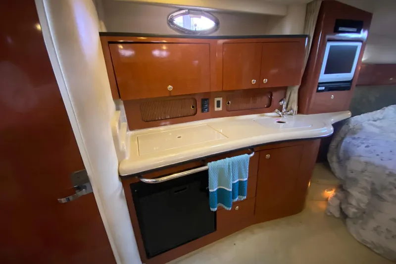 Slide: The Image of 2004 Sea Ray Sundancer 320 interior kitchen with wooden cabinets and modern amenities. - 30