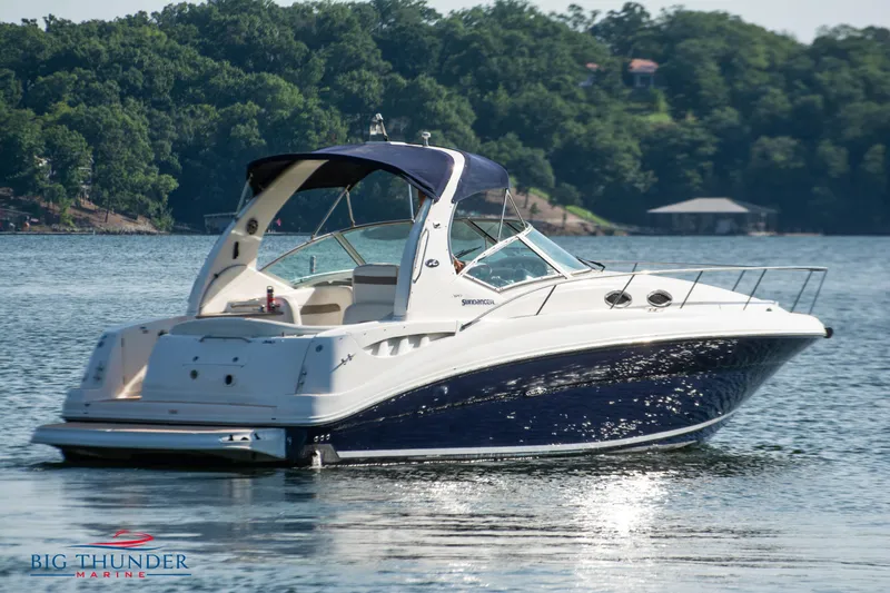 Slide: The Image of 2004 Sea Ray Sundancer 320 boat on a serene lake with lush green background. - 5