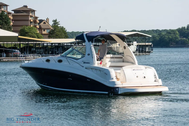 Slide: The Image of 2004 Sea Ray Sundancer 320 boat cruising near marina with scenic background. - 6