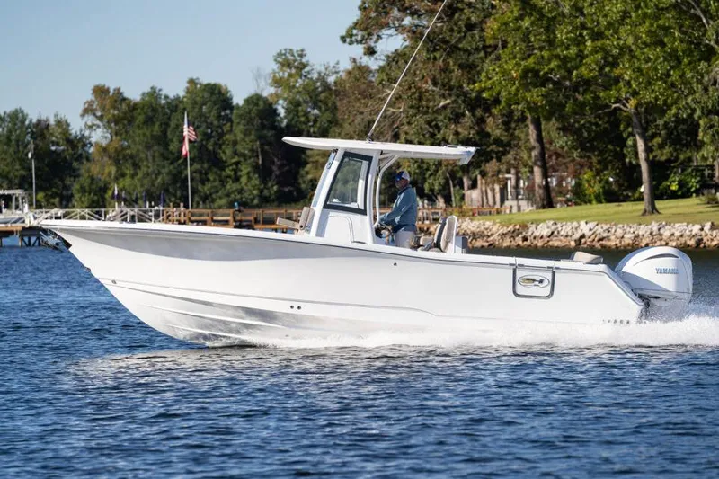 Slide: The Image of Manufacturer Provided Image: 2026 Sea Hunt Ultra 275 Coffin Box boat cruising on a scenic lake. - 0
