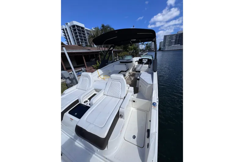Slide: The Image of 2024 Sea Ray SDX 290 Outboard boat with luxurious seating, docked by waterfront buildings. - 10