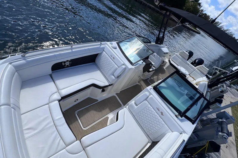 Slide: The Image of 2024 Sea Ray SDX 290 Outboard boat with luxurious seating on a serene waterfront. - 11