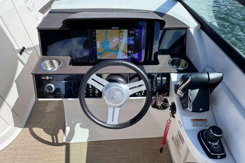 Slide: The Image of 2024 Sea Ray SDX 290 Outboard helm with steering wheel, navigation display, and controls. - 12