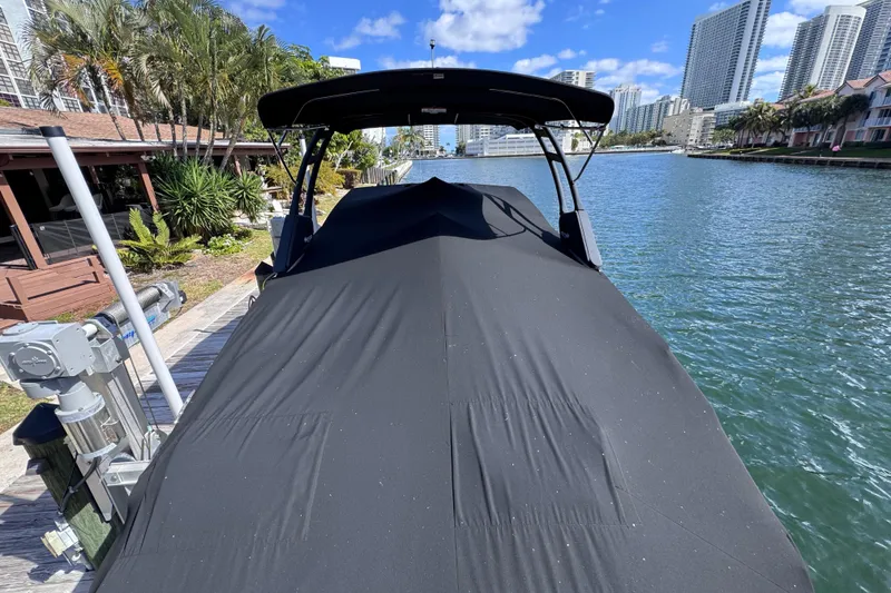 Slide: The Image of 2024 Sea Ray SDX 290 Outboard covered, docked by waterfront with cityscape background. - 20