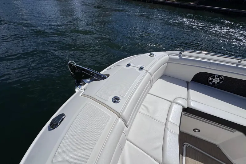 Slide: The Image of 2024 Sea Ray SDX 290 Outboard boat with white seating, docked on calm water. - 23