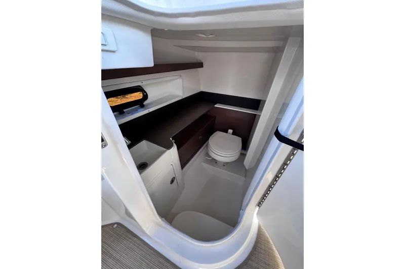 Slide: The Image of 2024 Sea Ray SDX 290 Outboard interior cabin with toilet and storage. - 29