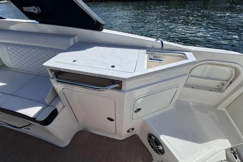 Slide: The Image of 2024 Sea Ray SDX 290 Outboard boat interior with sink and seating area. - 33