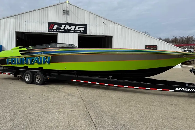 The Image of 2002 Fountain 42 Lightning speedboat in vibrant green on trailer outside HMG building. - 1