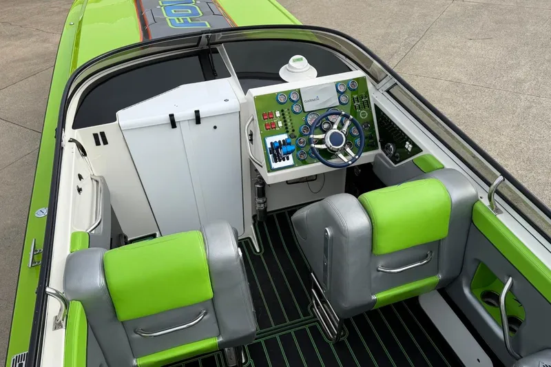 Slide: The Image of 2002 Fountain 42 Lightning boat interior with green accents and modern dashboard. - 8