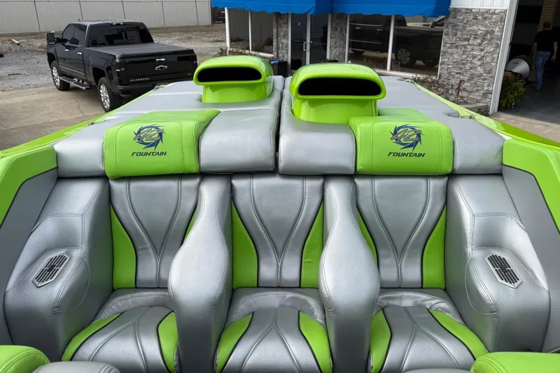 Slide: The Image of 2002 Fountain 42 Lightning boat interior with green and silver seats, parked near a black truck. - 9