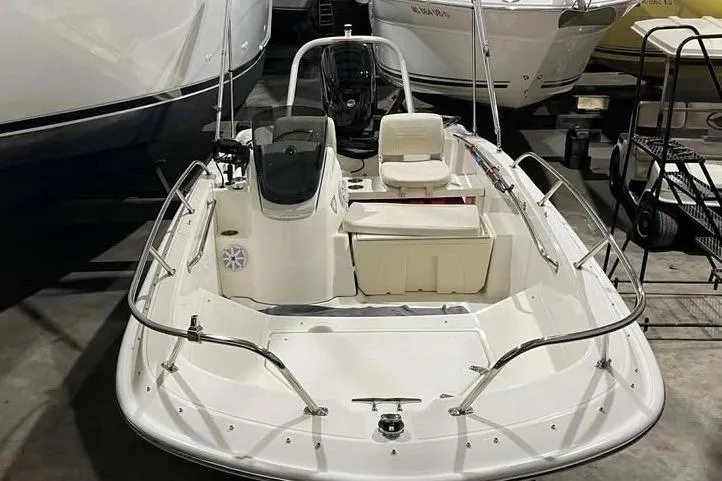 Slide: The Image of 2023 Boston Whaler 160 Super Sport boat in storage, showcasing sleek design and seating arrangement. - 4