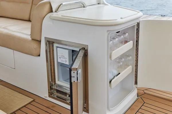Slide: The Image of 2018 MJM 40z yacht interior with open mini fridge and beige seating. - 26