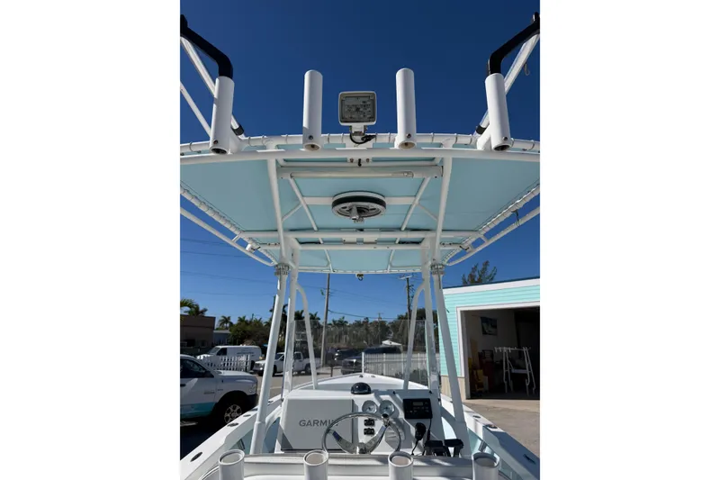 Slide: The Image of 2005 Albury Brothers 23 boat with T-top and Garmin electronics, docked under clear blue sky. - 6