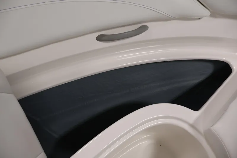 Slide: The Image of 2006 Bayliner 195 Bowrider interior detail, featuring sleek white seating and storage compartment. - 12
