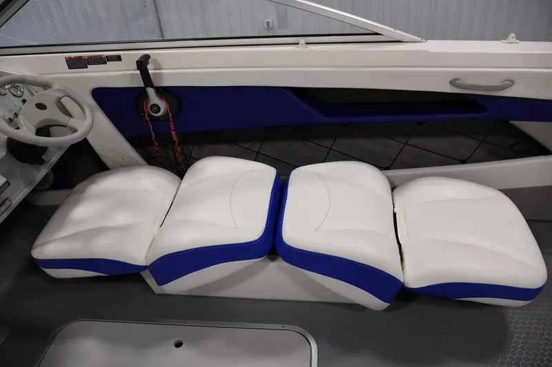 Slide: The Image of 2006 Bayliner 195 Bowrider interior with white and blue seating and steering wheel. - 23