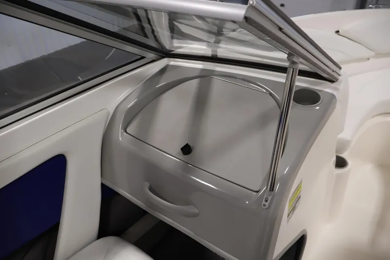 Slide: The Image of 2006 Bayliner 195 Bowrider interior detail with windshield and storage compartment. - 24