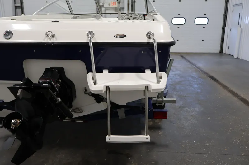 Slide: The Image of 2006 Bayliner 195 Bowrider boat stern with swim platform and ladder in a garage. - 40