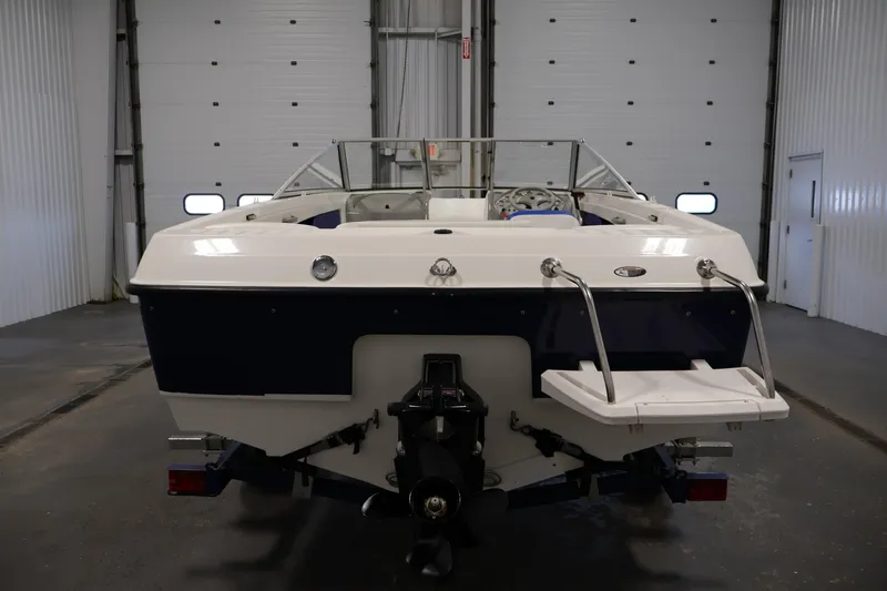 Slide: The Image of 2006 Bayliner 195 Bowrider boat in a garage, rear view with swim platform. - 6