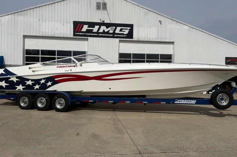 The Image of 2000 Fountain 38 Lightning boat with American flag design on trailer outside HMG building. - 1