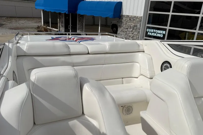 Slide: The Image of Interior of a 2000 Fountain 38 Lightning boat with white seating and a blue awning outside. - 23